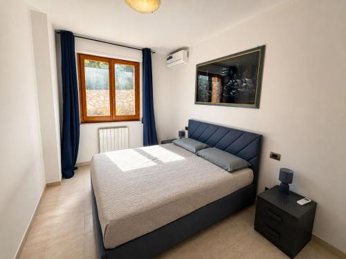 a bedroom with a bed with a blue head board at La Perla in Passignano sul Trasimeno