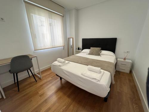 a bedroom with a bed and a desk and a window at Candle Home Sáenz Díez in Ourense