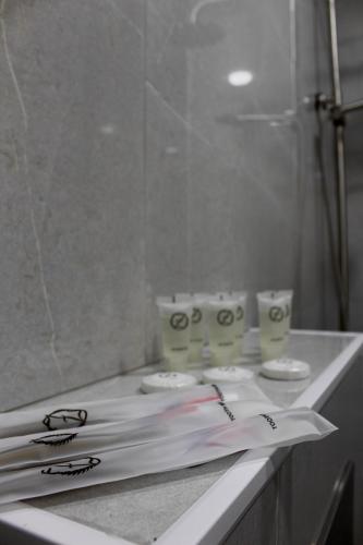 a bathroom counter with three toilets and a mirror at Hotel Zich in Kobuleti