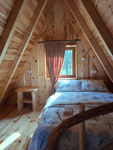 a bedroom in a log cabin with a bed and a window at Vikendica Smolovic in Žabljak