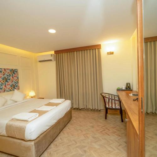 a hotel room with a bed and a desk and a desk at The Clock Tower Inn in Bangalore