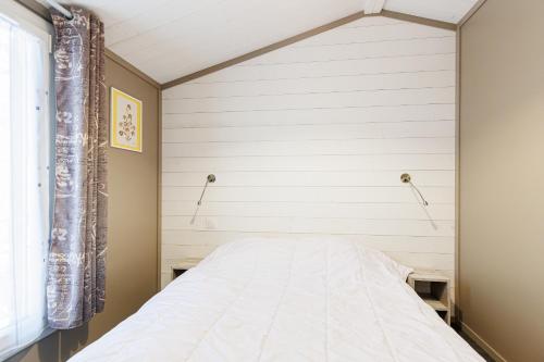 a bed in a bedroom with a white wall at Azur de La Cigale -Conciergerieland in Azur