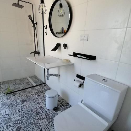 a bathroom with a toilet and a sink and a mirror at Cabaña sobre el Lago Cholila in Cholila