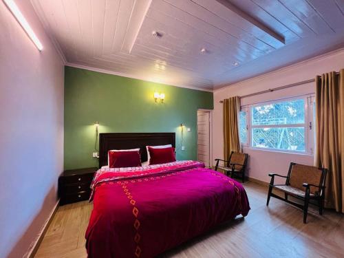 a bedroom with a large bed with a red blanket at Haven Daisy Meadows - 2BR Cottage with Lawn in Changla Gali in Chhāngla Gali
