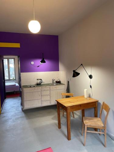 a kitchen with a table and a purple wall at Farbenfrohes Appartment in Wittenberge in Wittenberge
