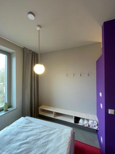 a bedroom with a bed and a purple cabinet at Farbenfrohes Appartment in Wittenberge in Wittenberge