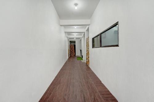 a hallway with white walls and a wooden floor at Hotel O Radha Krishna Family Hotel in Naubatpur