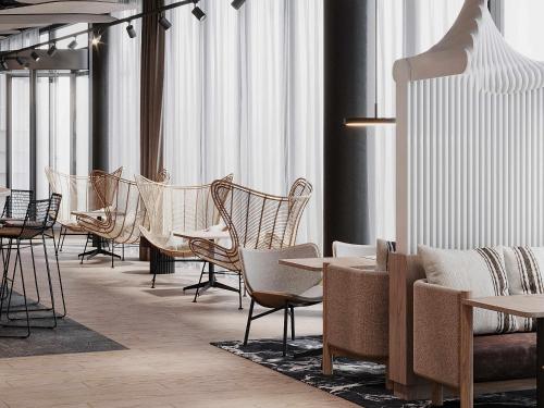 a row of chairs and tables in a room with windows at Mercure Hotel Delémont in Delémont
