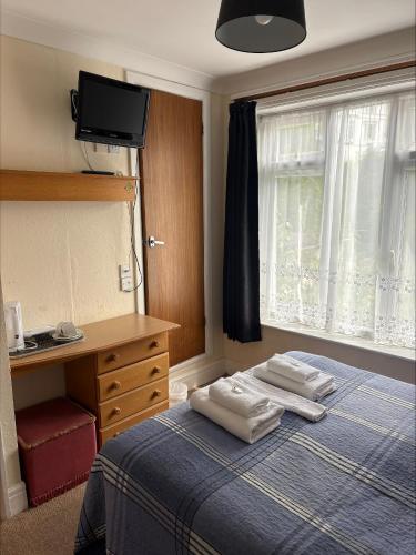 a bedroom with a bed with two towels on it at The Burlington Hotel in Torquay