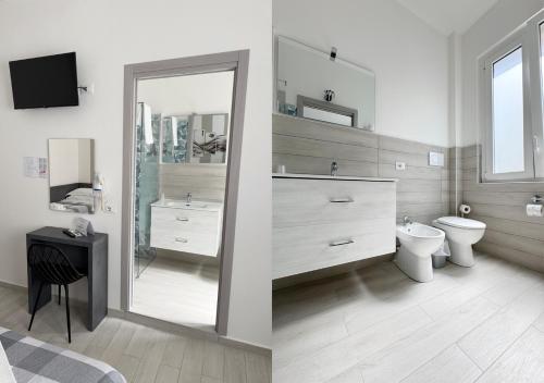a bathroom with a sink and a toilet and a mirror at chiAma Hotel in Rimini