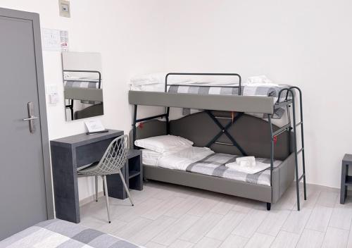 a room with two bunk beds and a chair at chiAma Hotel in Rimini