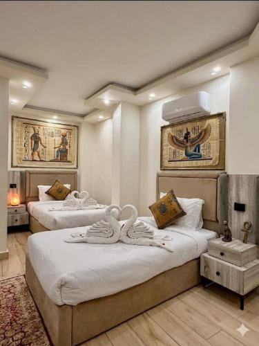 a hotel room with two beds with towels on them at Pyramids Art Inn in Cairo