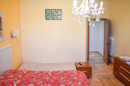 a bedroom with a bed and a chandelier at Penthouse Angelo Brunetti in Rome