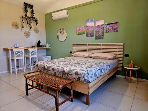 a bedroom with a bed and a bench in it at Chicche di Lavanda in Valmadonna