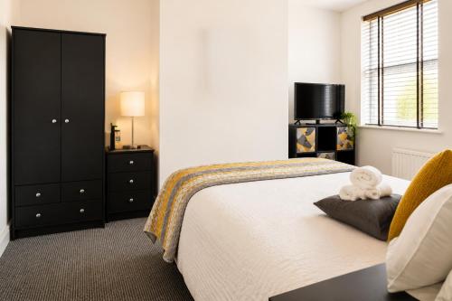 a bedroom with a bed and a chair and a television at Cinderhouse Highbury Vale in Nottingham