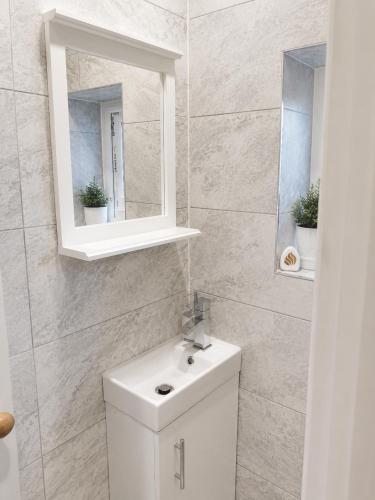 a bathroom with a white sink and a mirror at Cinderhouse Highbury Vale in Nottingham