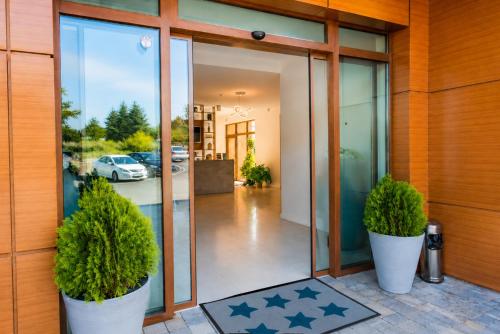 a house with two potted plants on the front door at St. Panteleimon Beach Hotel in Nesebar