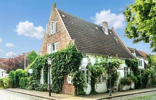 an ivy covered building with a church at Herzog Friedlich Hotel Garni in Friedrichstadt