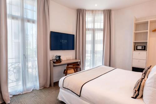 a bedroom with a bed and a desk and windows at Crisol Belle Epoque in Cannes