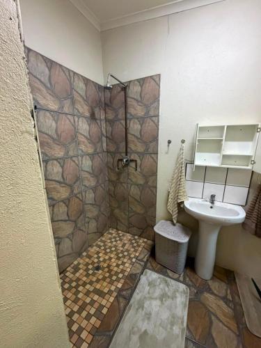 a bathroom with a shower and a sink at Root&Roam Nature in Malelane