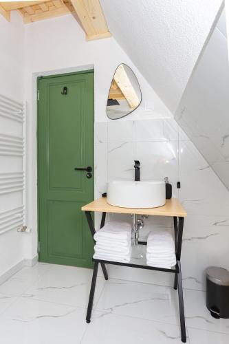 a bathroom with a green door and a sink at DejaView Cabin&Camp in Rogojel