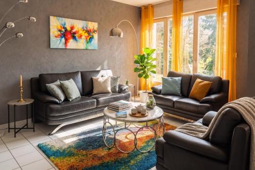 a living room with two couches and a table at Villa Pré d'Oro 5 étoiles 10 personnes, spa privé, nature, Vosges Saônoises in Amage