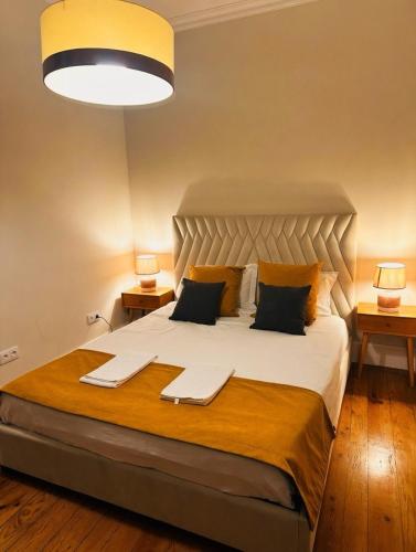 a bedroom with a large white bed with two lamps at Best House Center - with Garage in Porto