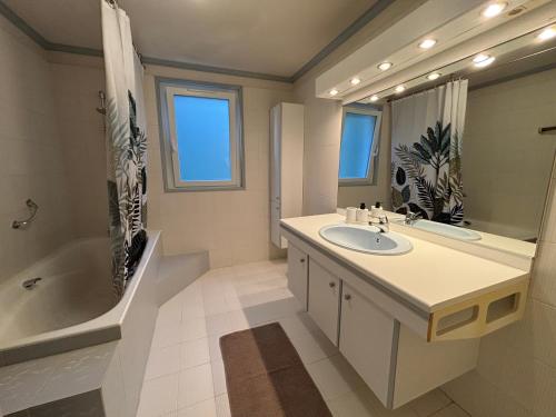 a bathroom with a sink and a tub and a mirror at La Maison du Bief in Écuisses