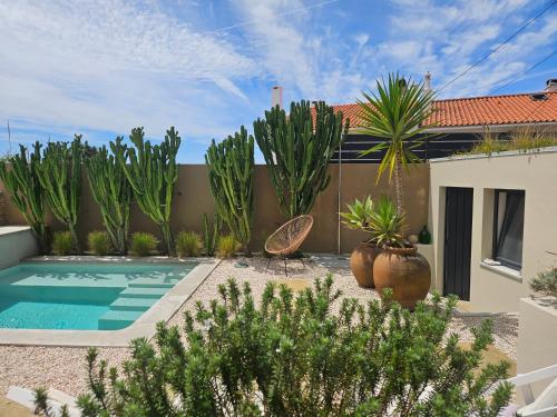 a backyard with a swimming pool and plants at Viladraga - Casa da Adraga in Colares
