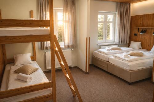 a bedroom with two bunk beds and two windows at Pokoje Pasáž in Doksy