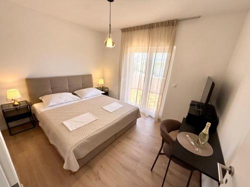 a bedroom with a bed and a television and a table at Dalmatinac Residence in Orebić