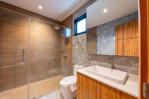 a bathroom with a sink and a shower and a toilet at King Arthur Pool Villa in Nong Prue