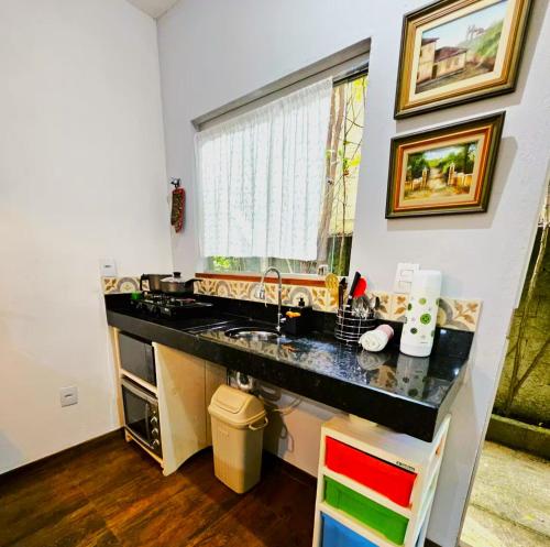 a kitchen with a sink and a window at Villa Pella - Chalé Tulipa- com café manhã in Brumadinho