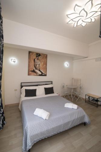 a bedroom with a large bed with two towels on it at Maa Guest House in Civitavecchia