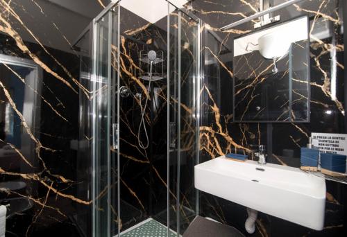 a bathroom with a black and gold marble wall at Maa Guest House in Civitavecchia