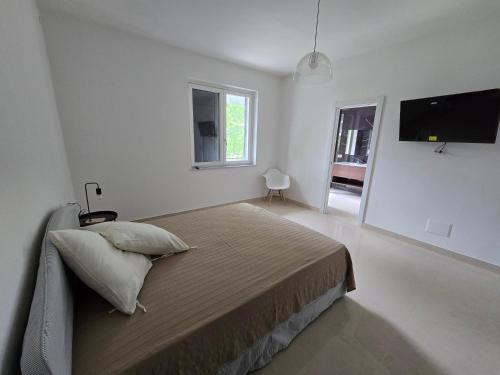 a bedroom with a bed and a flat screen tv at b&b la Conocchia in Curti