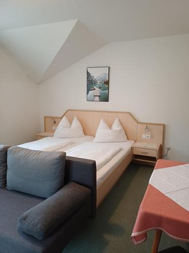 a bedroom with a large bed and a couch at Haus zur Linde in Wagrain
