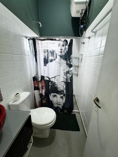 a bathroom with a toilet and a shower curtain at Raíces Vivas Dúplex - Cochera Privada en Oberá in Oberá