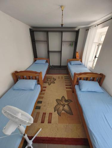 a small room with three beds and a fan at Old Town Casa in Ulcinj