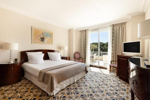 a hotel room with a bed and a television at Hôtel Juana in Juan-les-Pins