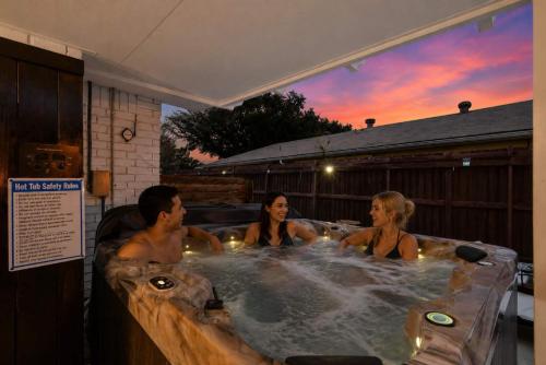 a group of people in a jacuzzi tub at Luxurious 5BR 2BA Holiday Home with Pool, Grill, Sauna & Game Room in The Colony
