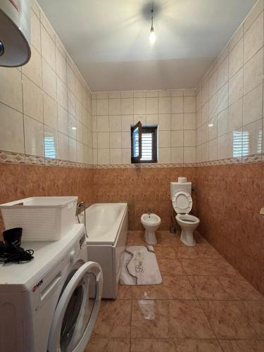 a bathroom with a washing machine and a toilet at Apartments Vukasović in Kotor