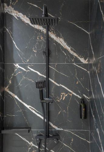 a shower with a black marble wall at Gerania nature Residence 22 in Siátista