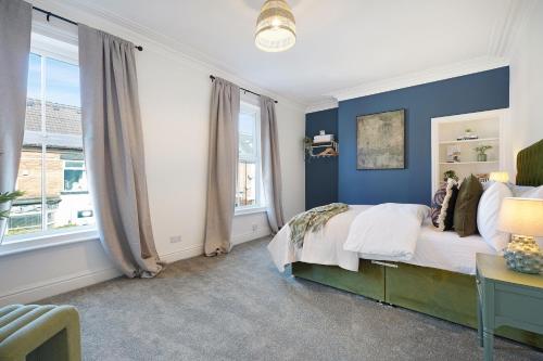 a bedroom with blue walls and a bed and a desk at Charming 4BR Retreat in Hull Sleeps 8 by Stay With Us in Hull