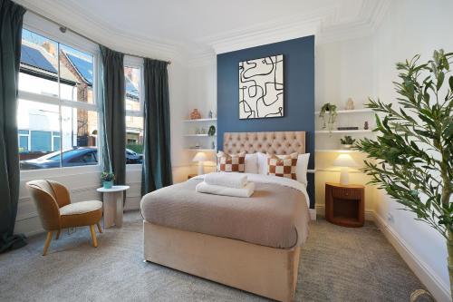a bedroom with a bed and a chair and windows at Charming 4BR Retreat in Hull Sleeps 8 by Stay With Us in Hull