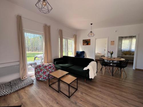 a living room with a green couch and a table at Cisza lasu in Kadłubówka