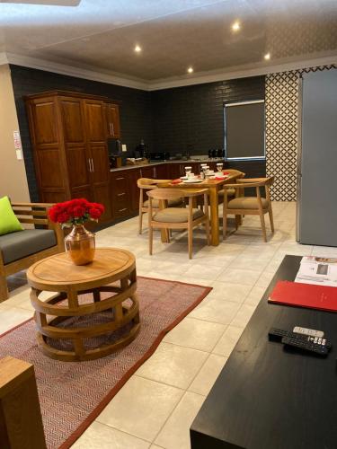 a living room with a table and a kitchen at N'taba River Lodge & Spa in Port St. Johns