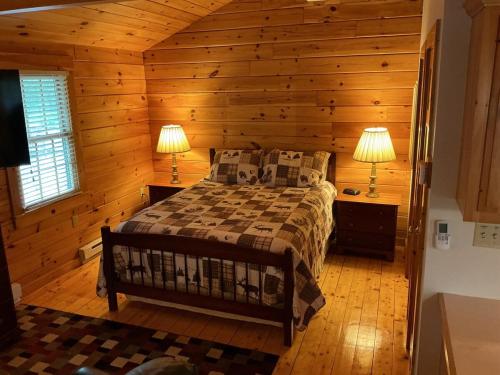 a bedroom with a bed in a log cabin at Rivers Edge Cabins - Deer Run in Cushing