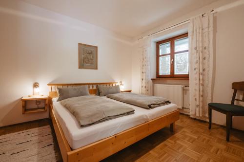 a bedroom with a bed with a wooden frame and a window at Balsnhof in Chamerau