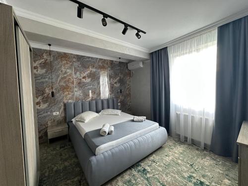 a bedroom with a large white bed and a large window at Camere de inchiriat KATALEYA in Mamaia Sat/Năvodari